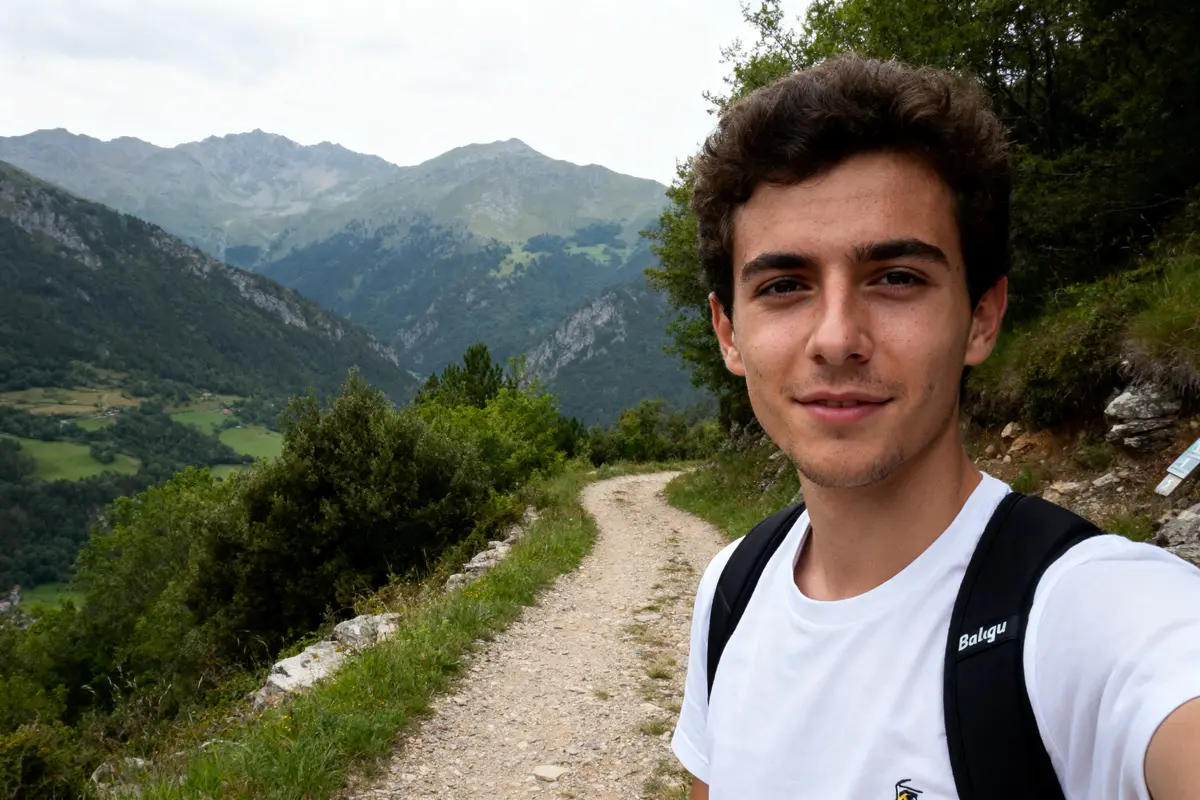 Jeune randonneur sur un sentier de montagne avec sac à dos Balagu en arrière-plan montagnard